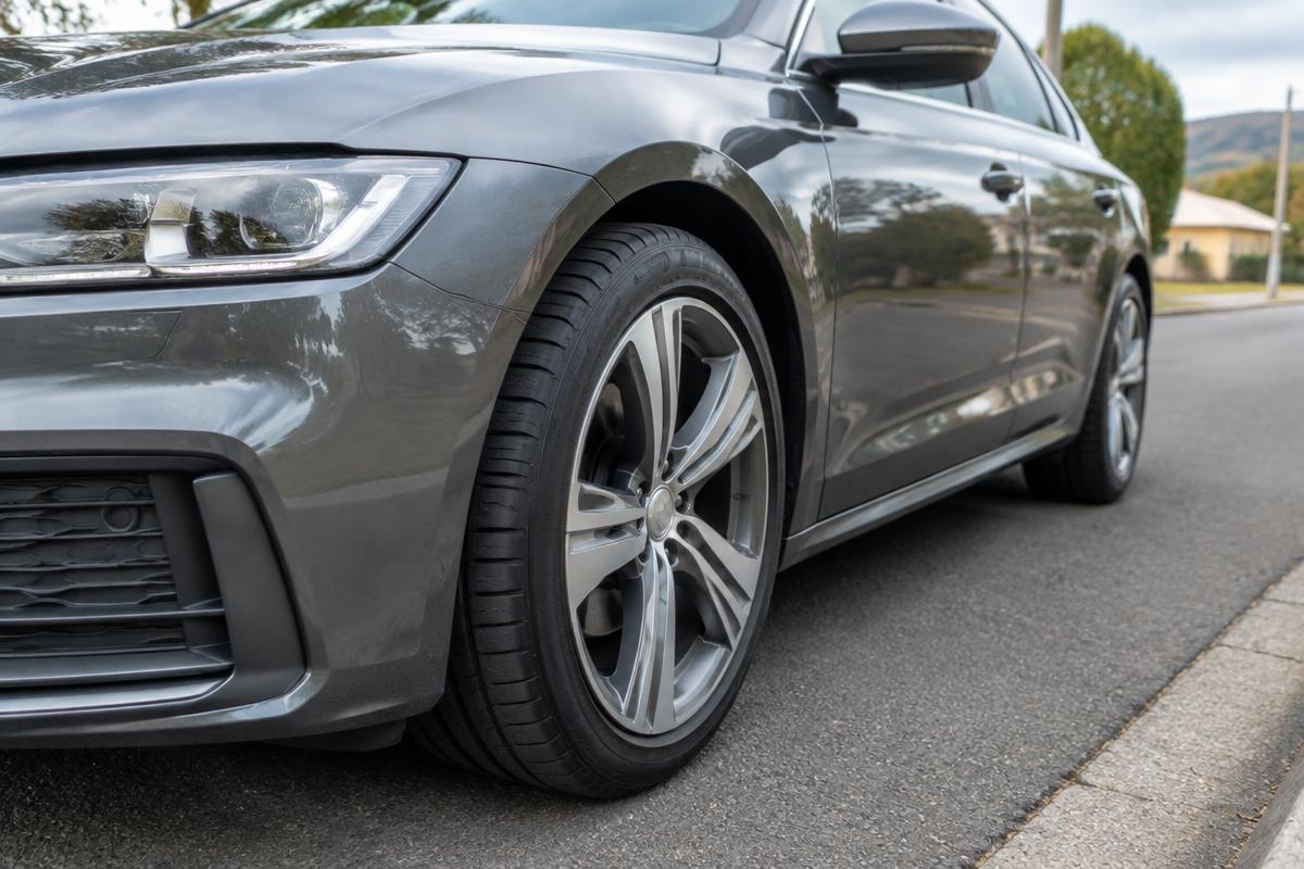 Close-up of the front run-flat tyre on a dark grey premium sedan.